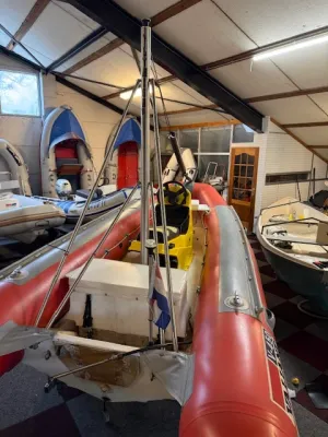 rode rubberboot in loods met meerdere boten