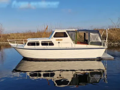 witte kruiser aangemeerd op rustig water