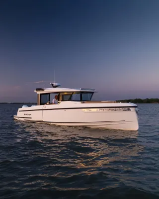 witte motorboot op rustig water bij schemering