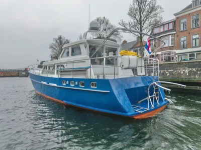 blauw motorjacht aangemeerd bij kade