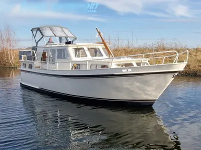 witte motorboot op water bij oever