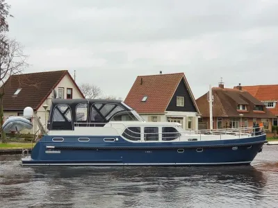 motorjacht in kanaal langs woonhuizen