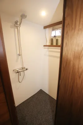 douche in kajuit met kraan en houten deur