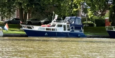 Blauwe motorjacht aangemeerd langs kade