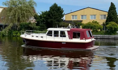 rood-witte kotter op kanaal voor woonhuizen