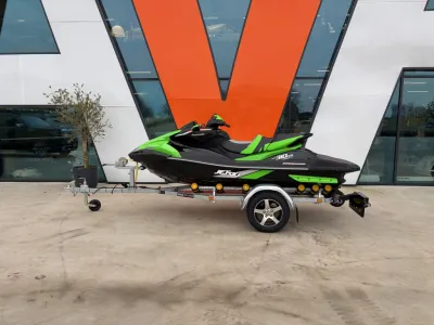 groene jetski op trailer voor gevel
