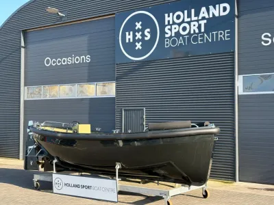 zwarte sloep op trailer voor bedrijfsgevel