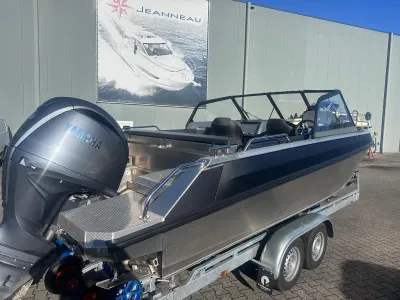 aluminium sportboot op trailer bij loods