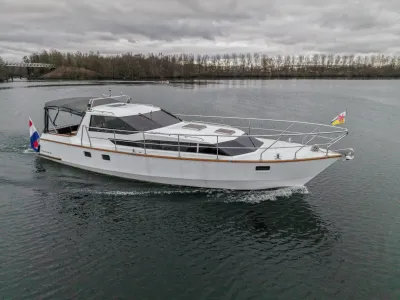 wit motorjacht op rustig water bij bewolkte lucht