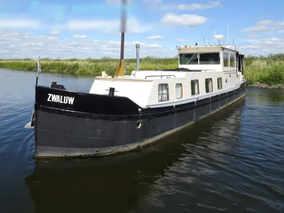 wit-zwart motorjacht op water