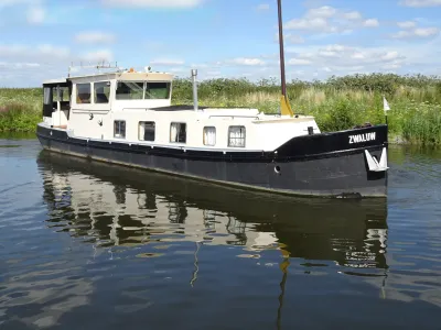 wit-zwarte woonboot op kanaal