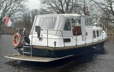 motorvlet aangemeerd op rustig water met bomen