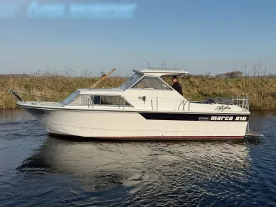 witte motorboot op rivier bij grasoevers