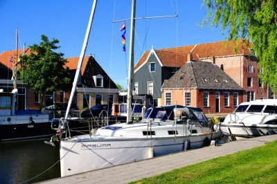 zeiljacht aangemeerd bij kade en gebouwen