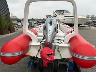 rode RIB met buitenboordmotor op trailer