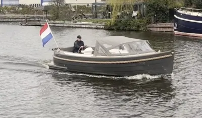 sloep op kanaal met nederlandse vlag