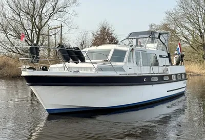 wit motorjacht op stil water bij oever