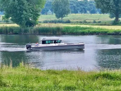 motorboot varend op rivier langs groene oever