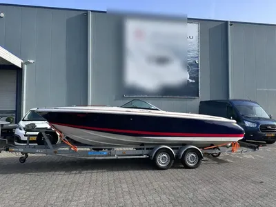 donkerblauwe speedboot op trailer bij gebouw
