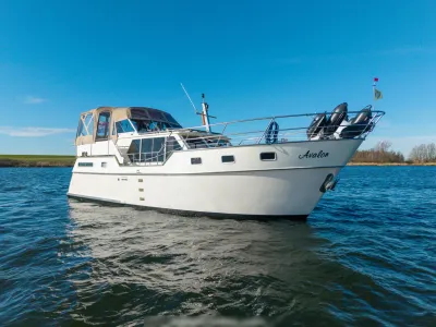 witte kruiser op stil water met blauwe lucht