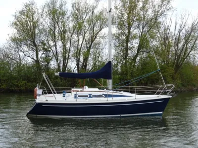 zeilboot op rustig water langs oever