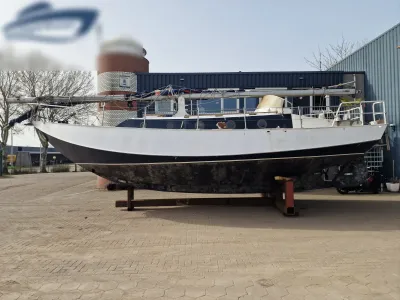 zeilschip op bokken voor loodsgebouw