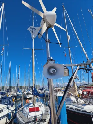 mast met windgenerator en jachten in haven