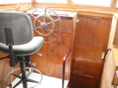 binnenruimte met houten stuurwiel en stoel