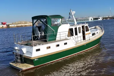 Motorjacht met groene romp aan het water