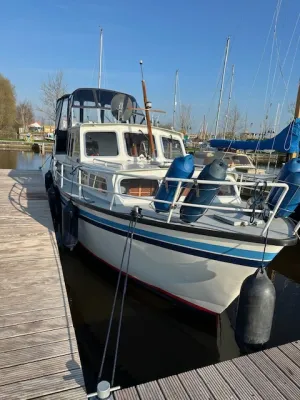 motorjacht afgemeerd bij houten steiger
