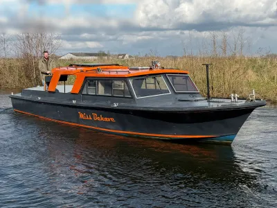 motorboot op kanaal met opbouw en bestuurder