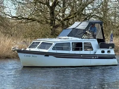 motorkruiser op rustig water bij riet