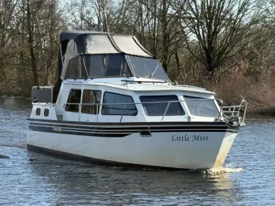 motorjacht op rivier met bomen op achtergrond