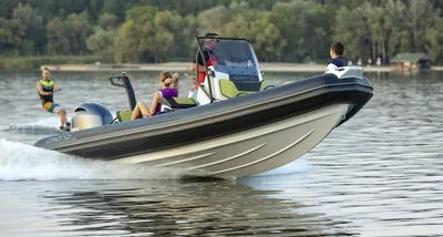 RIB met passagiers en wakeboarder op een meer