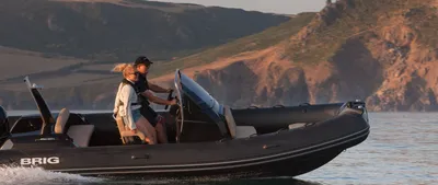 RIB met twee personen bij kust