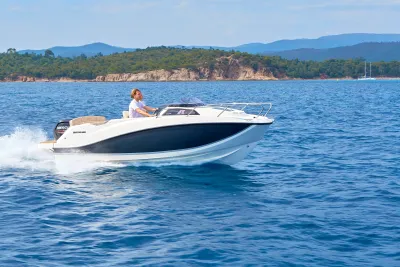 motorboot op open water bij een rotskust