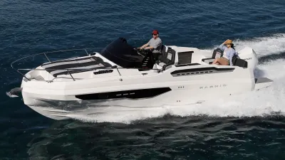 witte motorboot met twee personen op zee