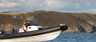 RIB op zee voor rotsachtige kust