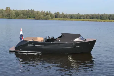 zwarte boot op kalm water met bomen op achtergrond