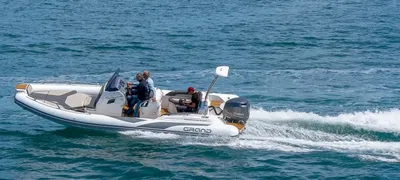 RIB-boot op zee met kustlijn op de achtergrond
