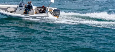 RIB met bemanning op zee bij kust