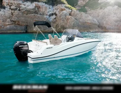 motorboot op blauw water bij rotsen