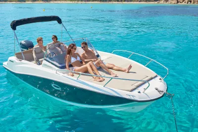 Motorboot met mensen op zonnedek in helder water