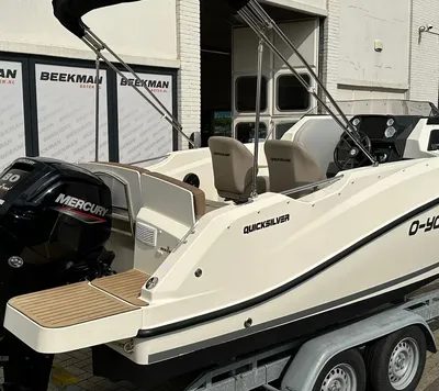 witte motorboot op trailer bij gebouw