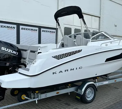 witte motorboot op trailer bij gebouw