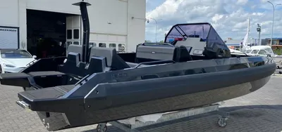 donkergrijze motorboot bij loods