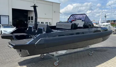 donkere sportboot buiten op trailer bij showroom