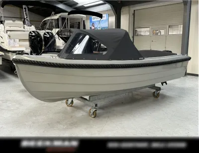 steengrijze sloep met overkapping in showroom