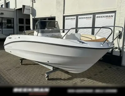 witte open consoleboot op trailer bij gebouw