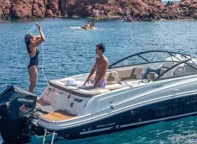 mensen op open motorboot bij rotsachtige kust